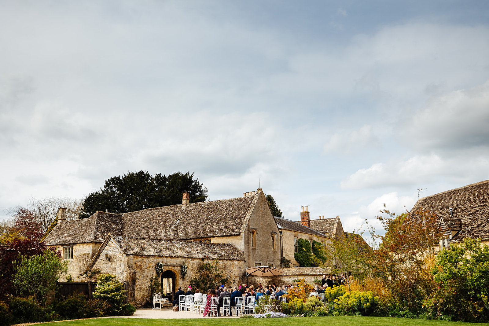 An image of a house with white chairs in the garden ready for an outdoor wedding ceremony