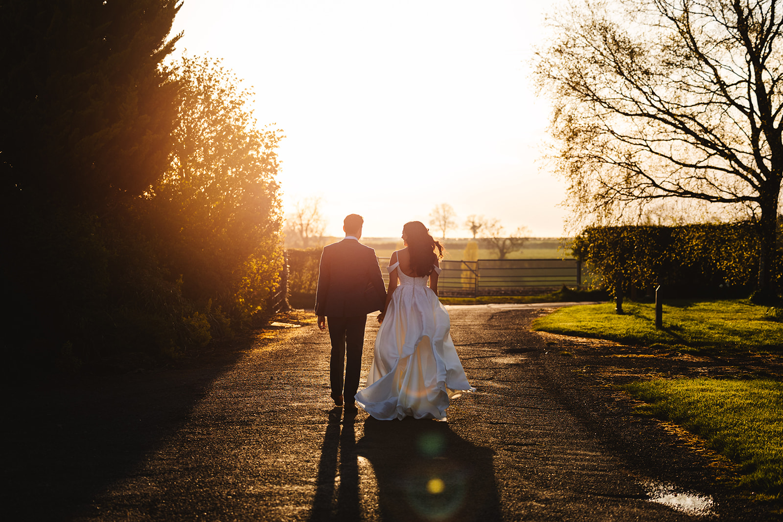 A bride and groom walking into the sunset