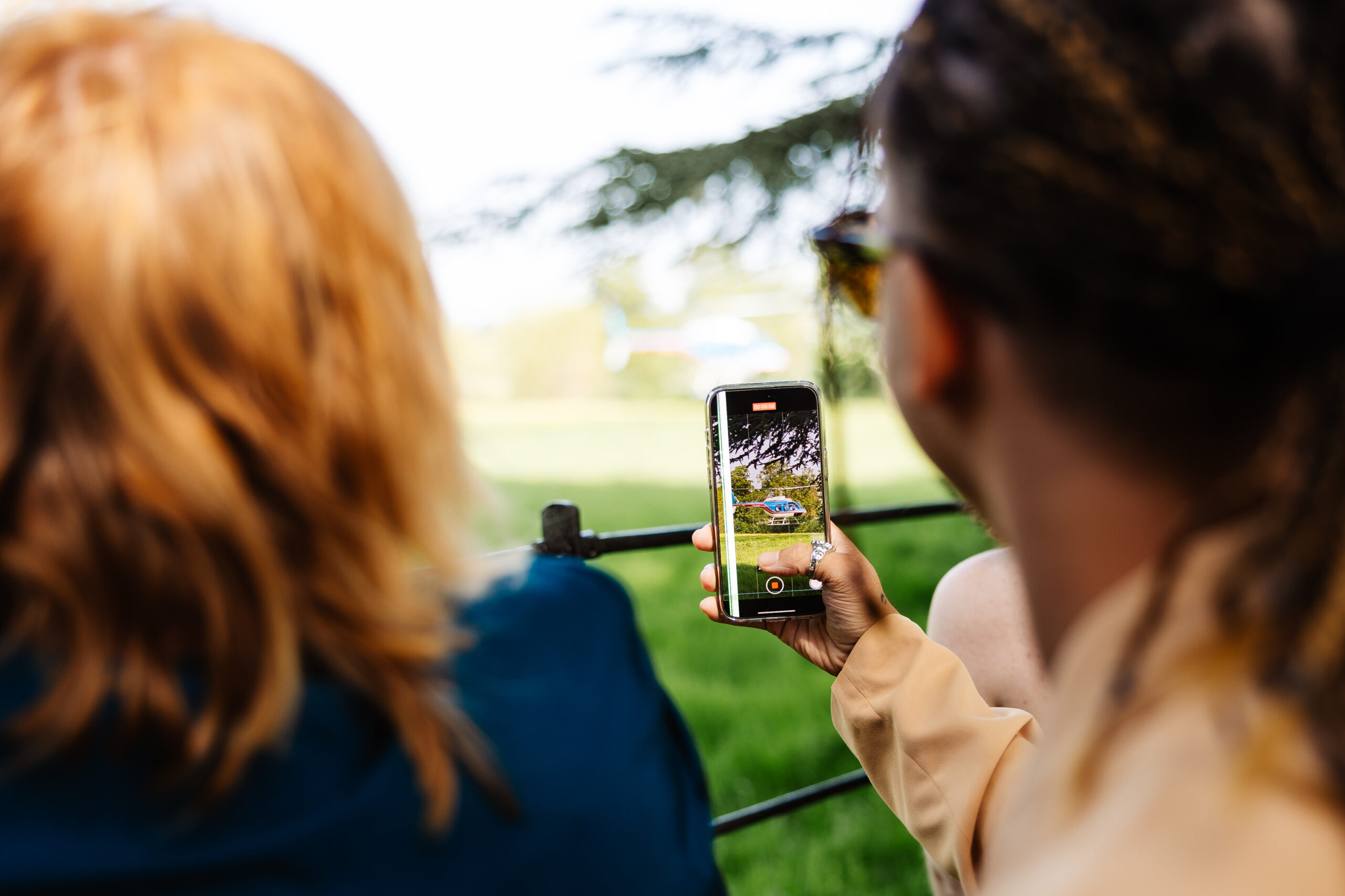 A guest holding up his phone to record a helicopter landing. You can see the helicopter on the phone screen.