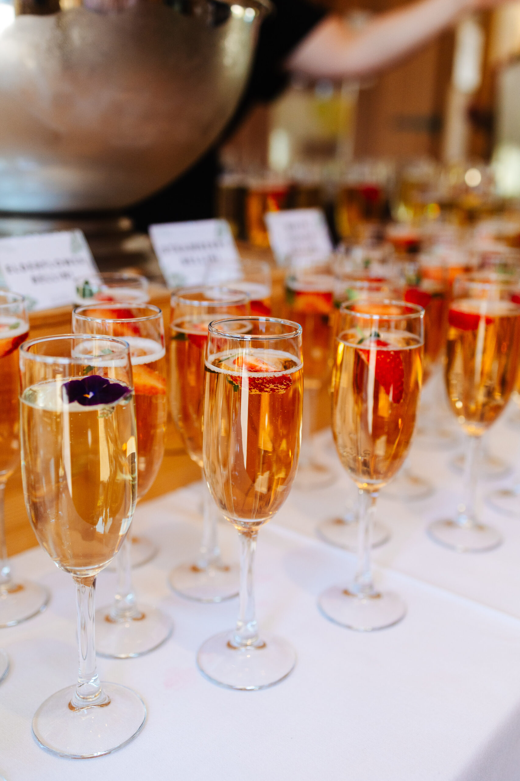 A photo of Pimms in glasses. They have edible flowers or a strawberry in them too.