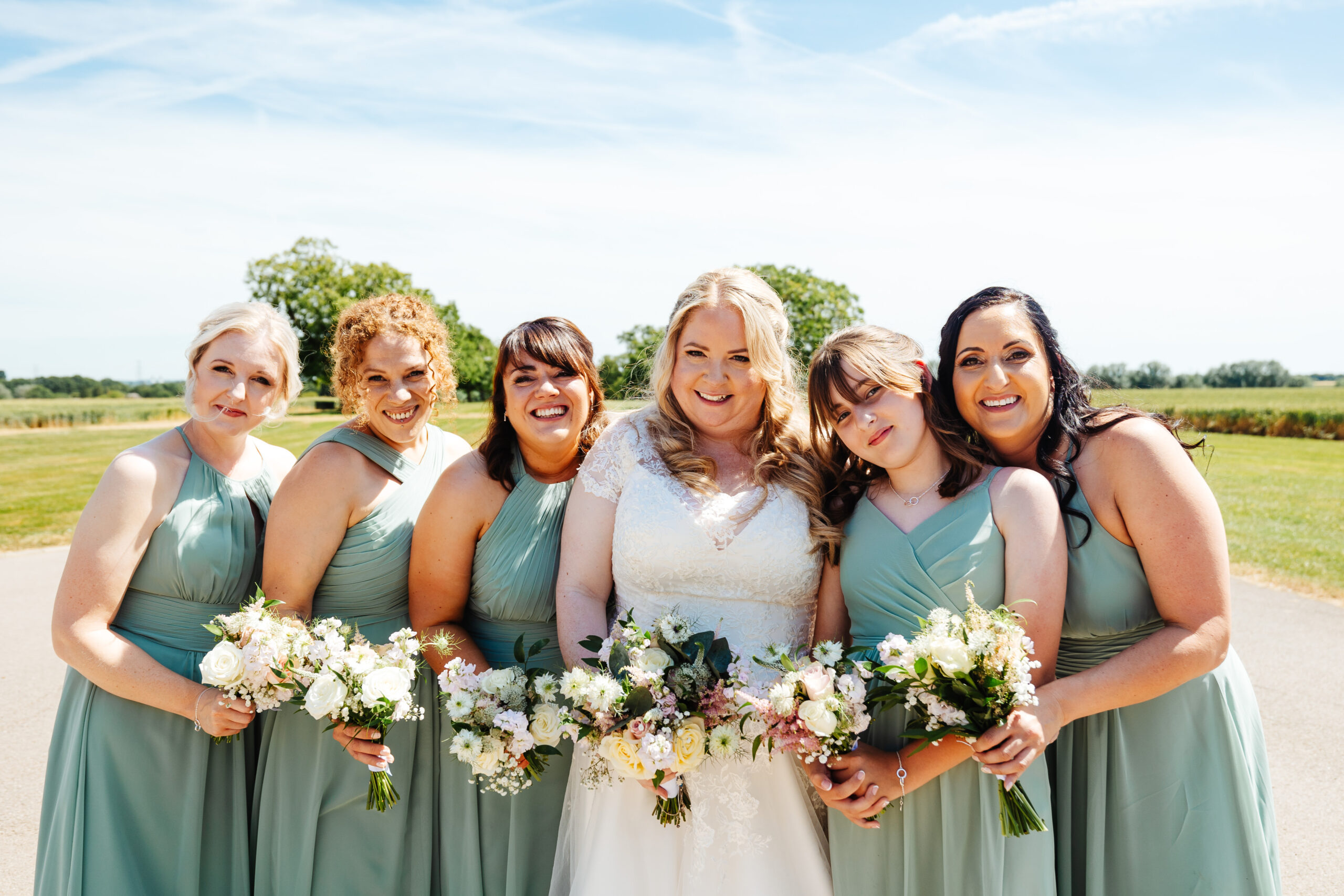 The bridal party. They are all huddled together in a line. 