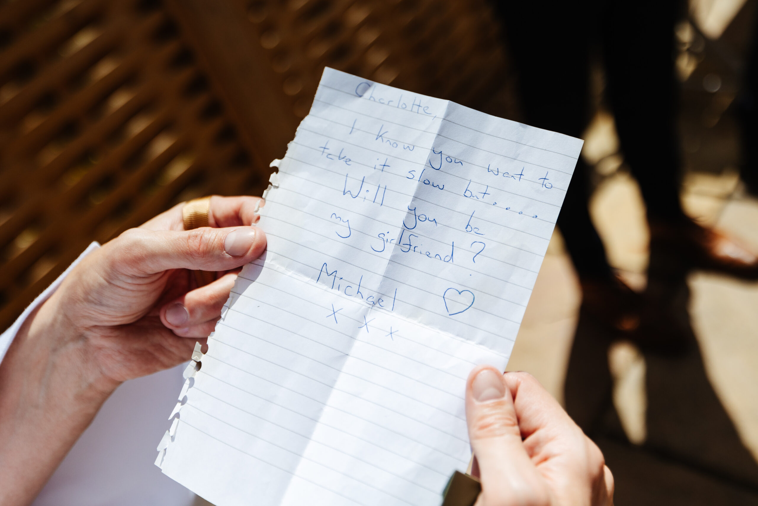 A hand written note on a bit of paper that says
Charlotte,
I know you want to take it slow but...Will you be my girlfriend? Michael (with a love heart and three kisses written on it).
