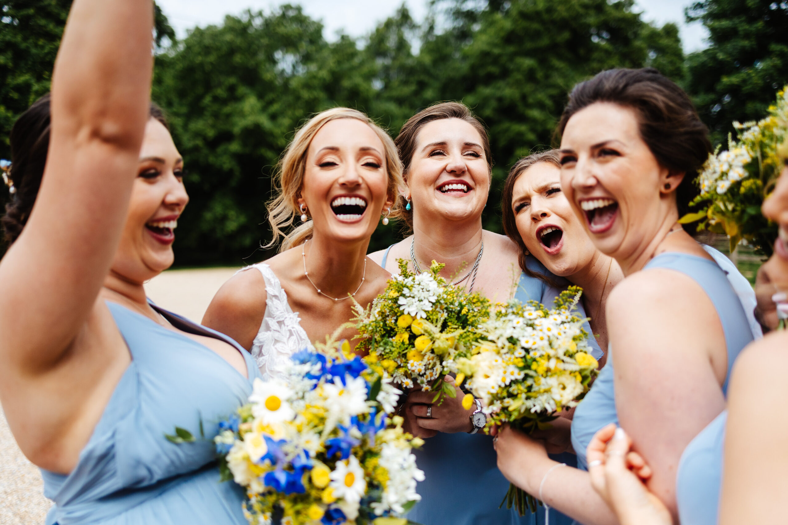 A group of ladies holding flowers and smiling widely