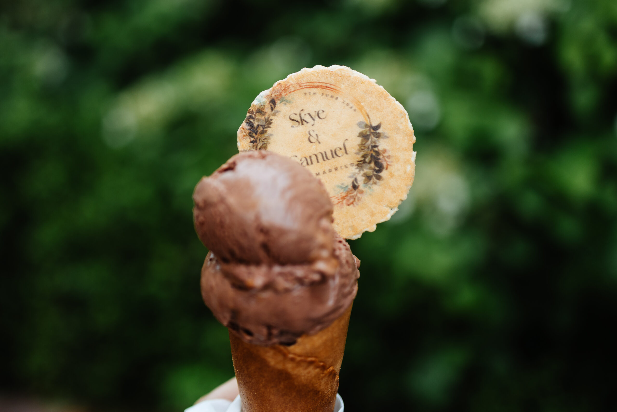 A chocolate ice cream in a cone with a biscuit that has the bride and groom's name on (Skye & Samuel)