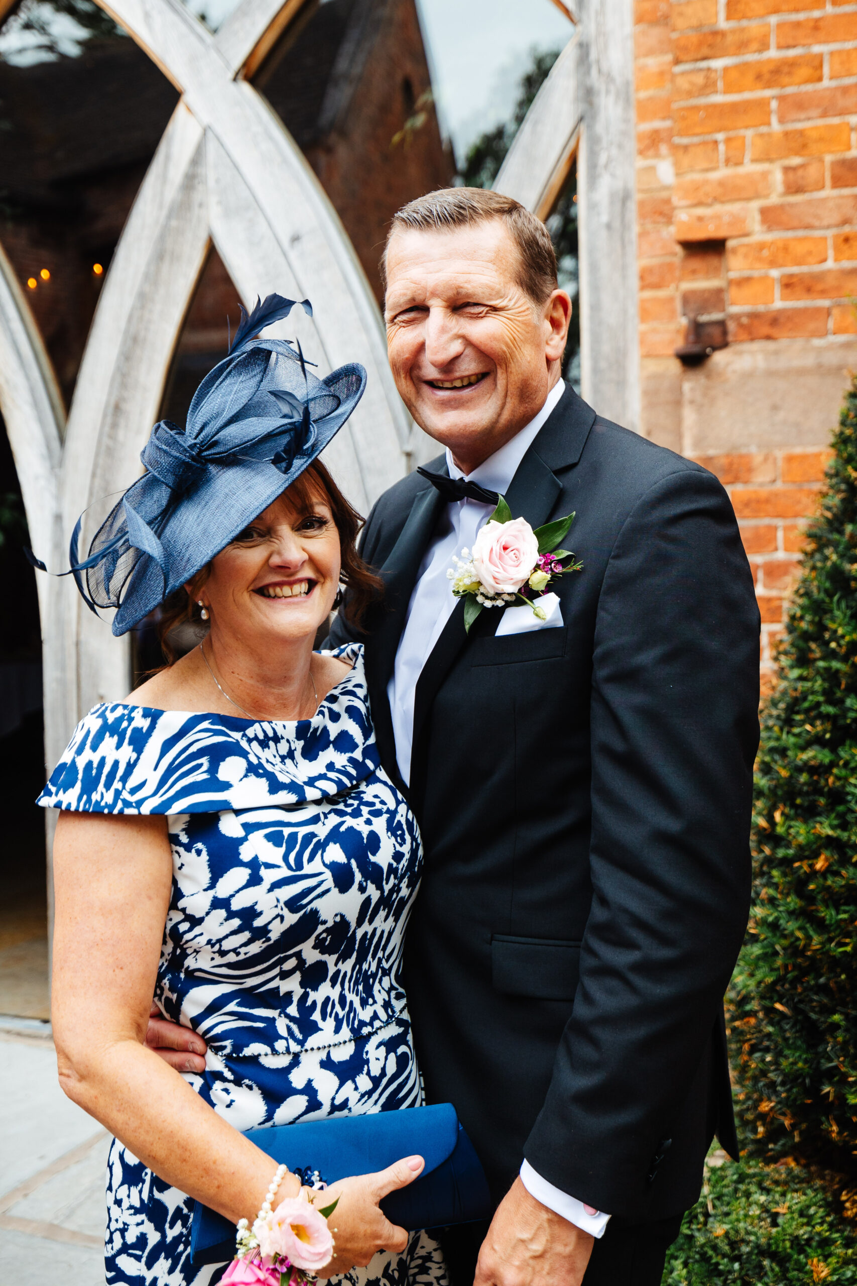 A photo of the groom's mum and dad. They are both smiling and looking at the camera.