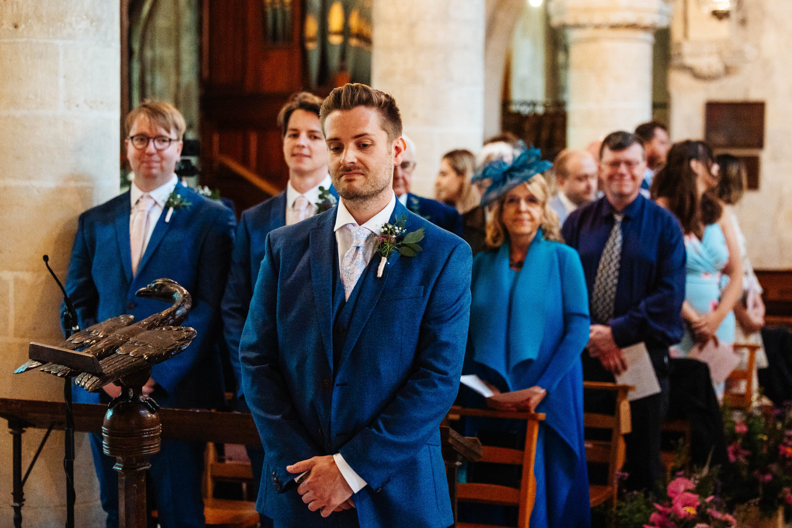 A photo of the groom standing nervously at the front of the alter in the church.