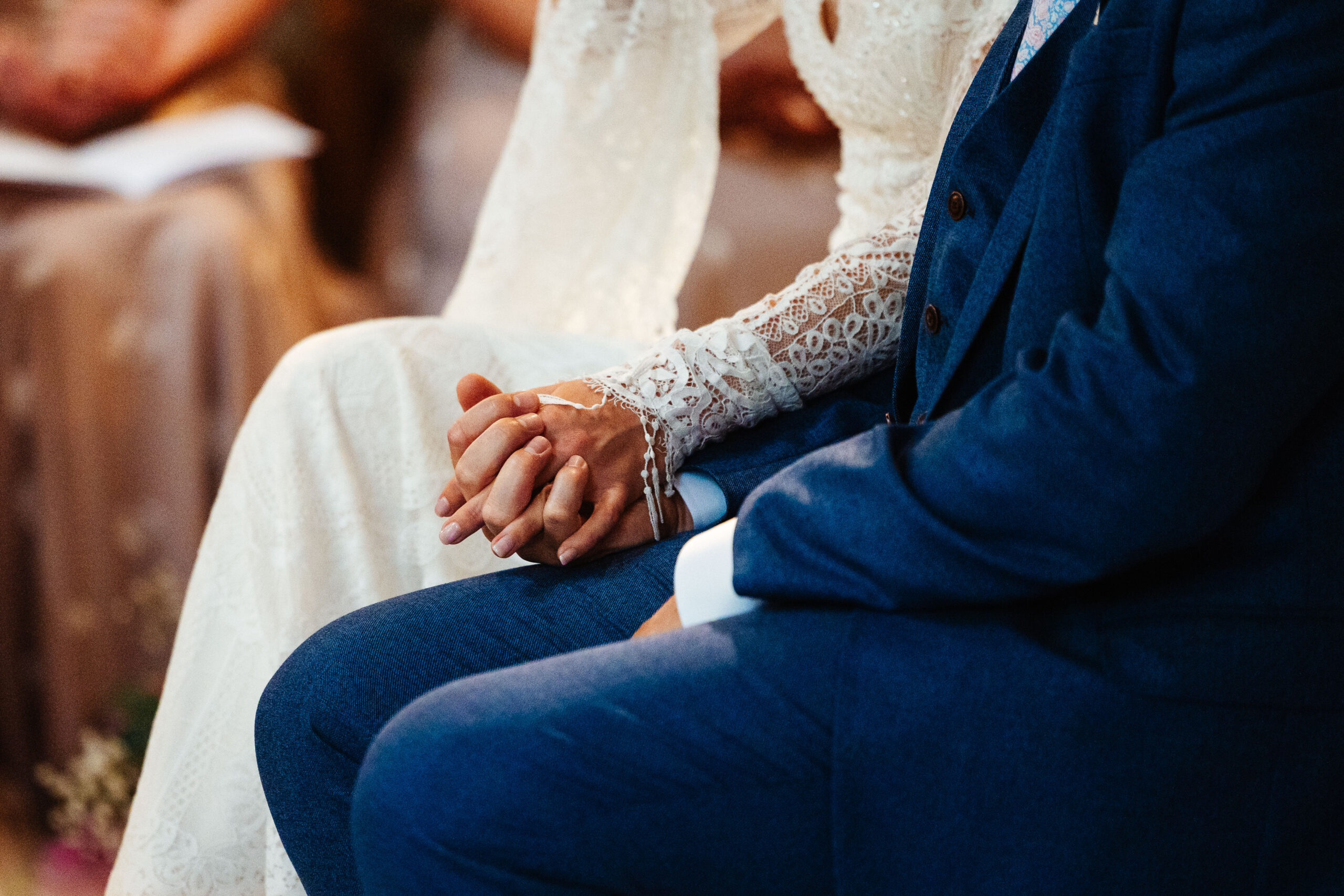 The bride and groom holding hands. It is zoomed in on their hands only.