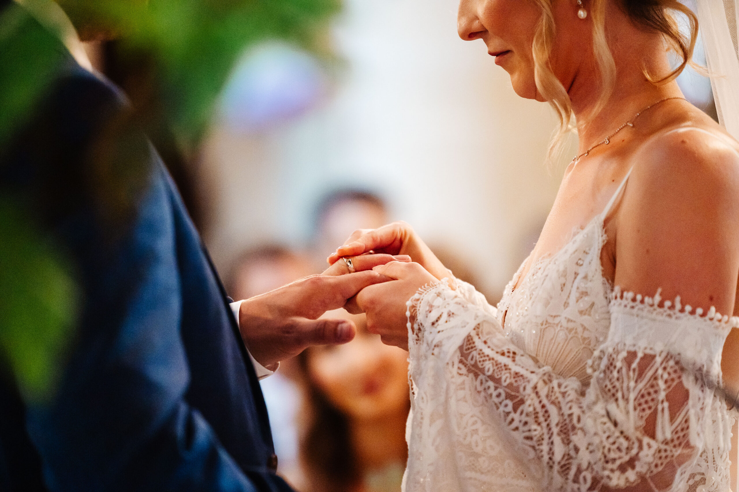 The bride putting the ring on her groom's finger.