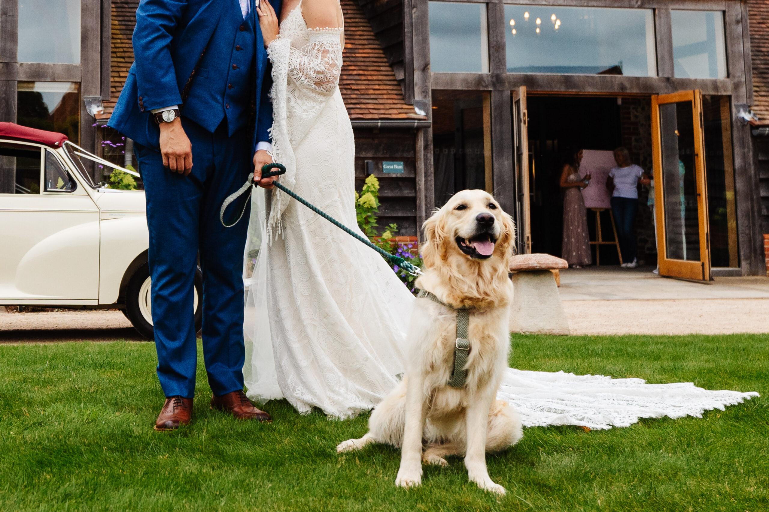 The bride, groom and their dog. The dog is a golden retriever. He has his tongue out and looks happy.