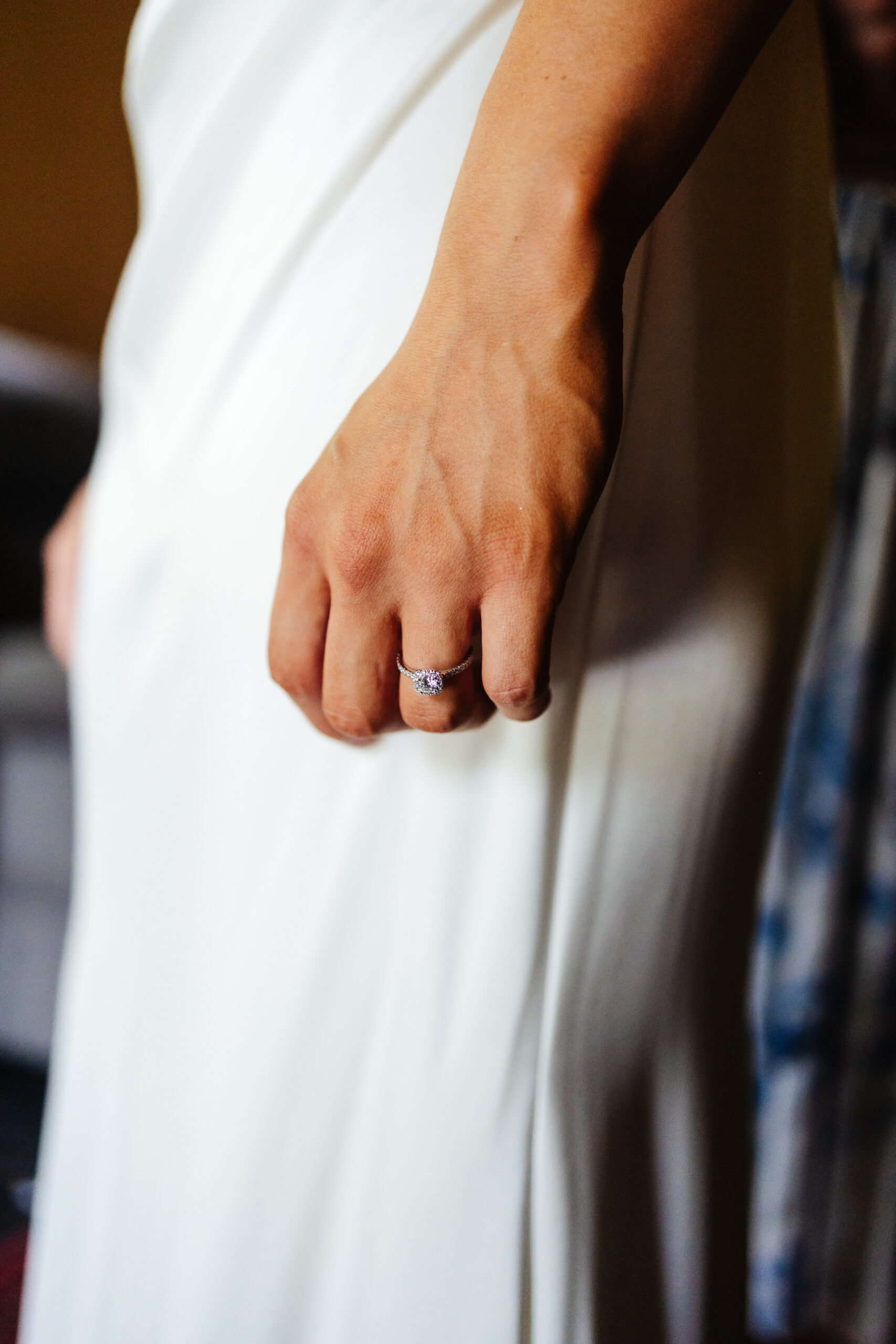 An image of Olivia (the bride)'s hand showing off her jewelled engagement ring.