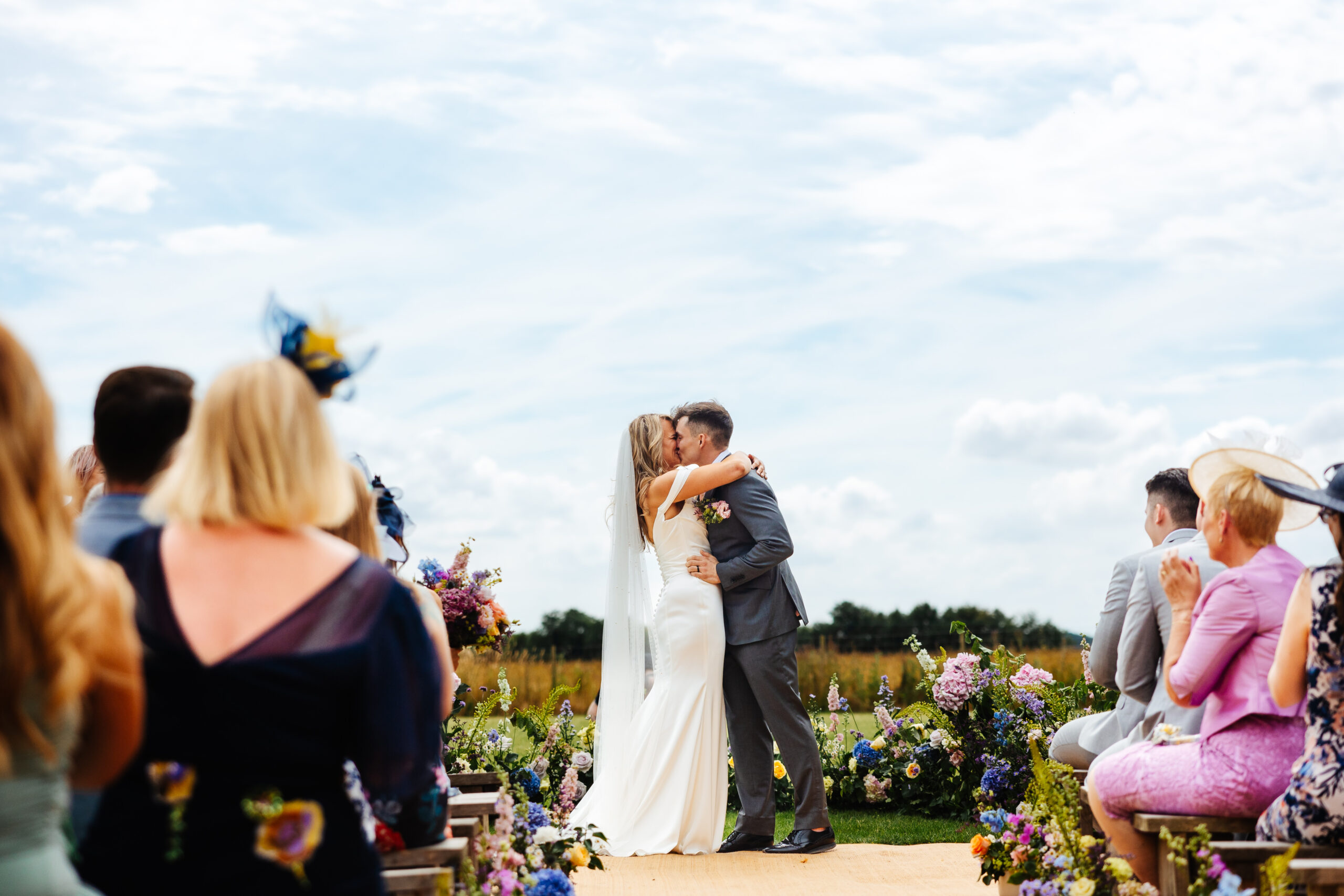 The bride and groom kissing at the to of the outdoor alter.