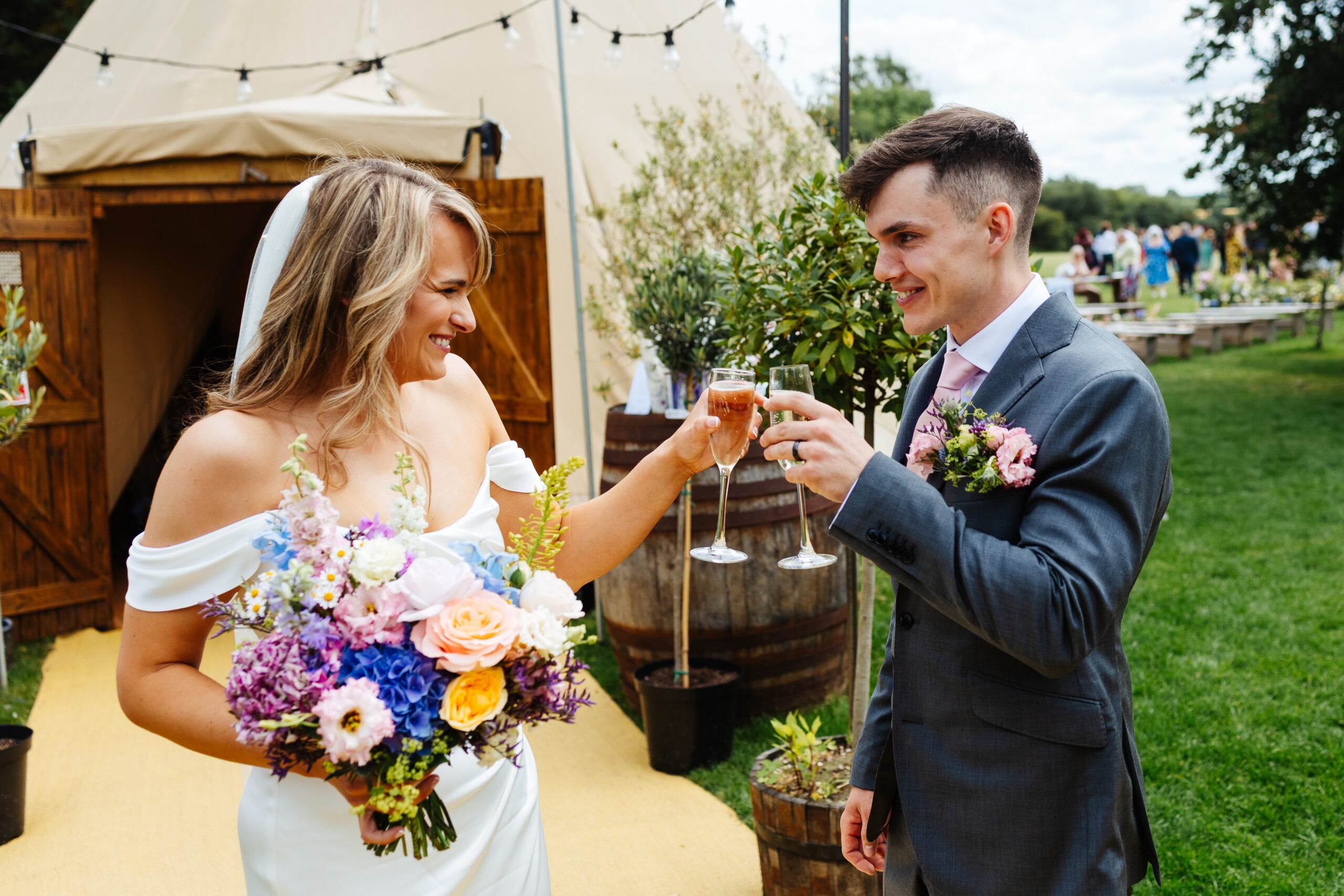 The bride and groom cheersing a toast with a glass of champagne.