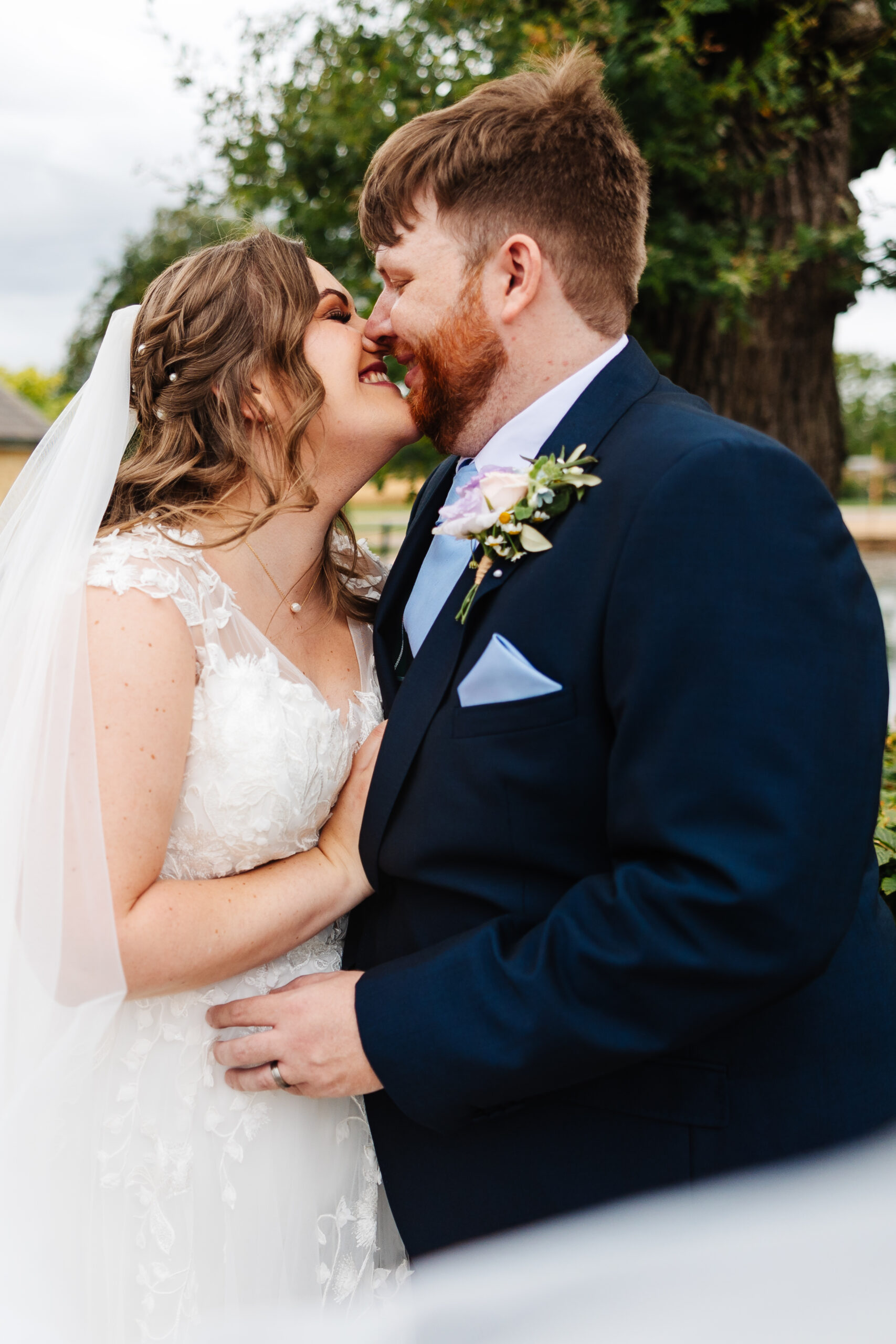 A close up shot of the bride and groom. They are smiling and almost kissing.