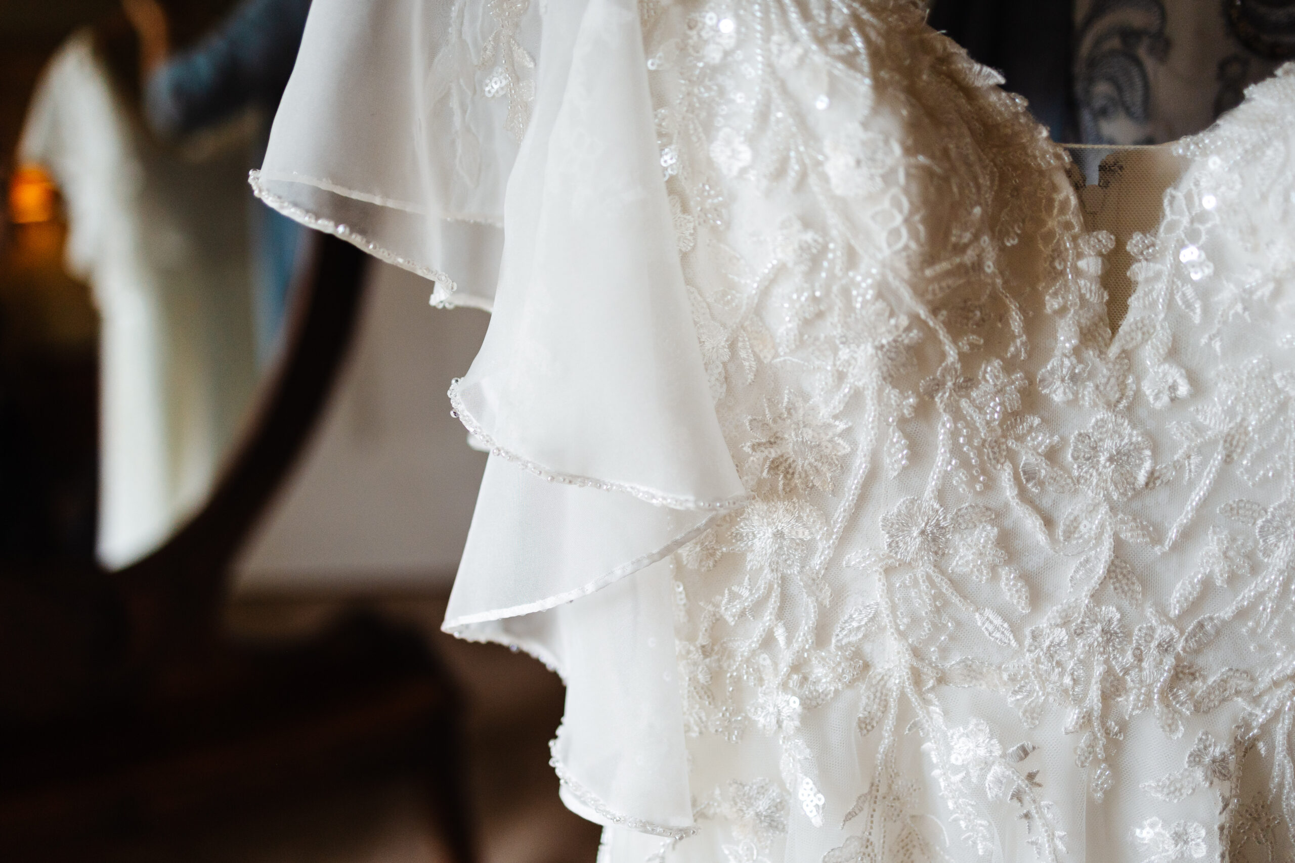 The front of the brides dress. She has beaded laced detail on the front of it.