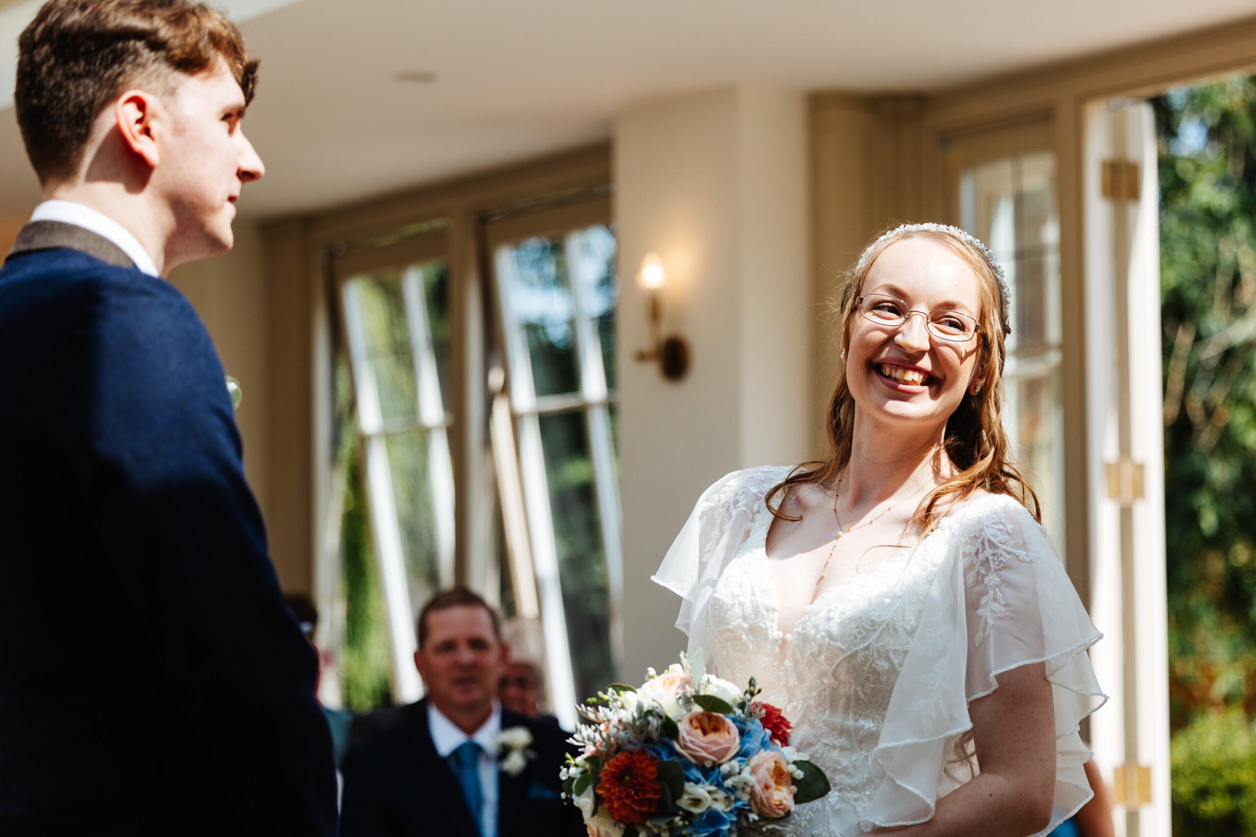 The bride and groom. The bride is looking at the celebrant and is smiling at her.