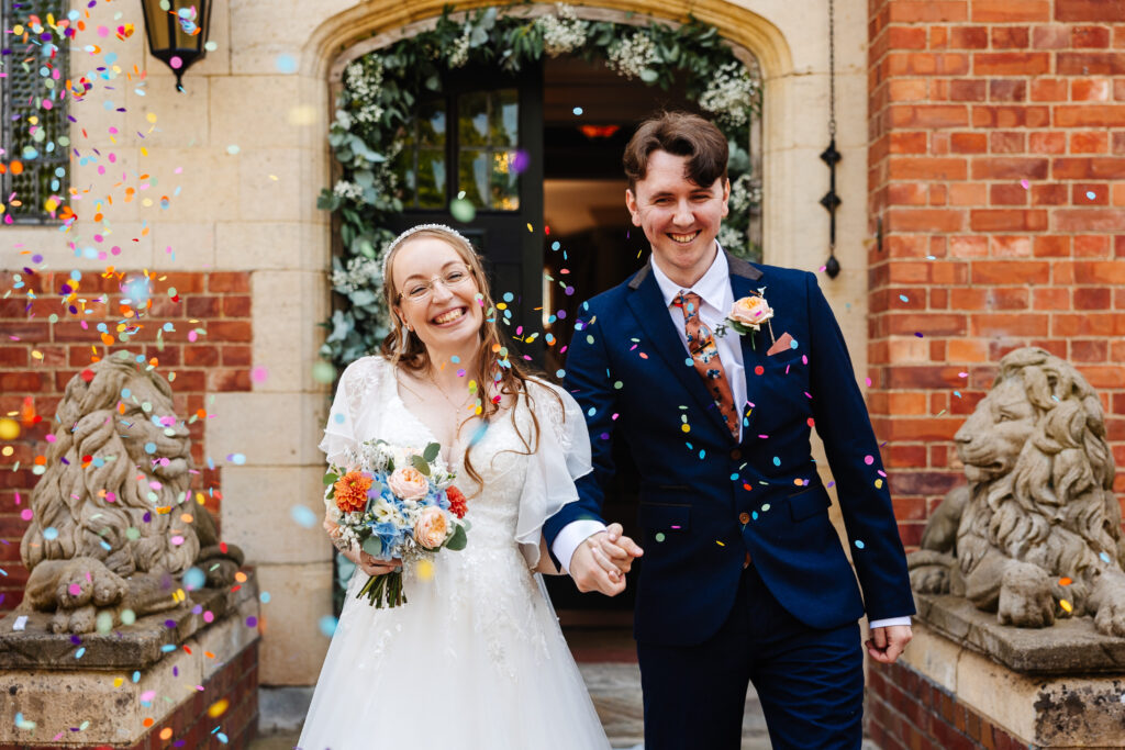 colourful confetti falling over a smiling bride and groom at plum park manor