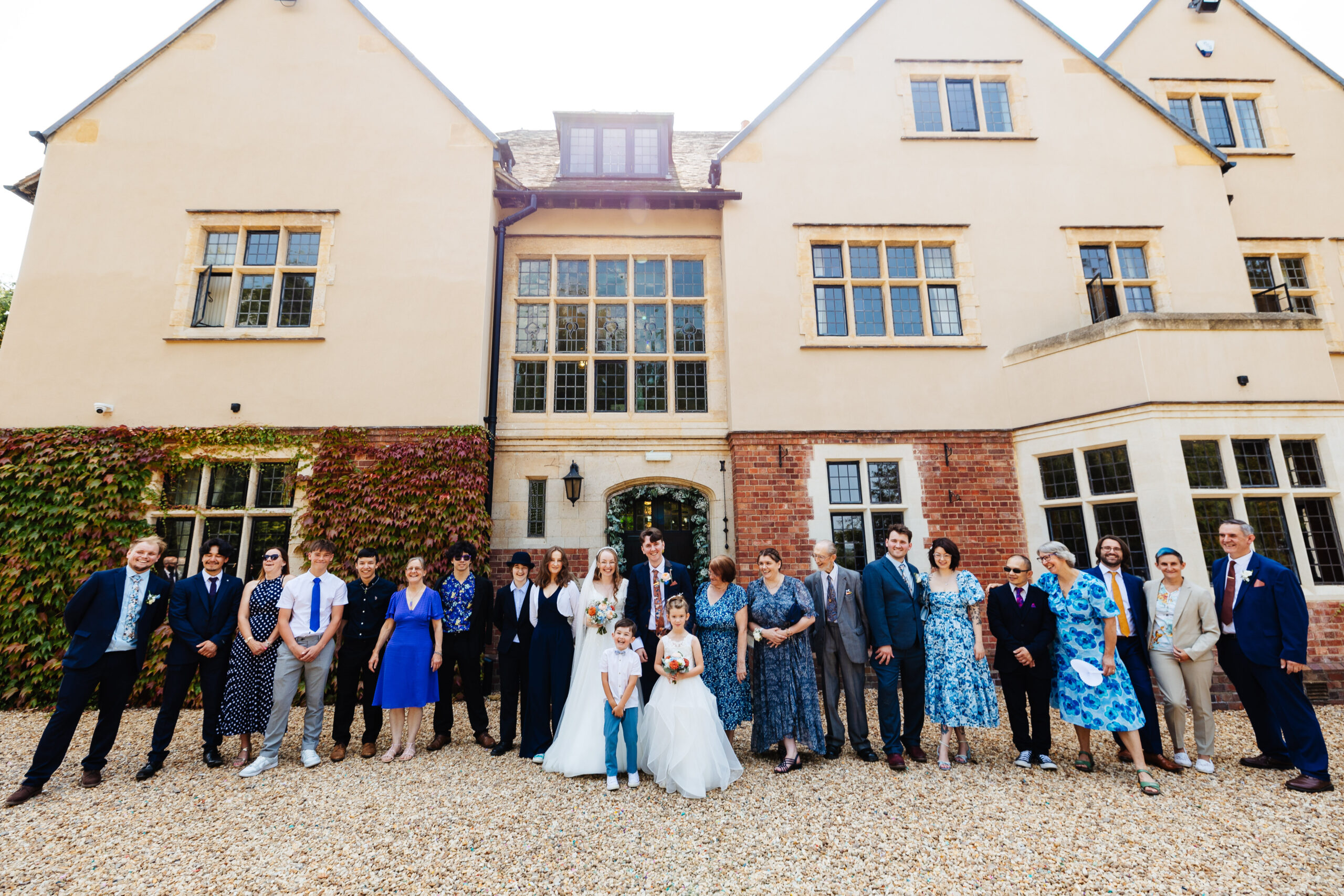 The bride and groom and their guests in front of the venue.