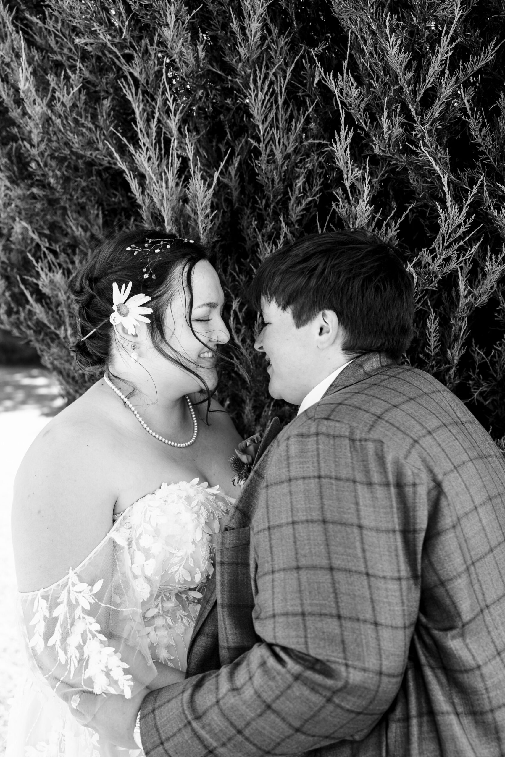 A black and white image of the brides. They are close to one another, holding one another but they have their eyes closed.