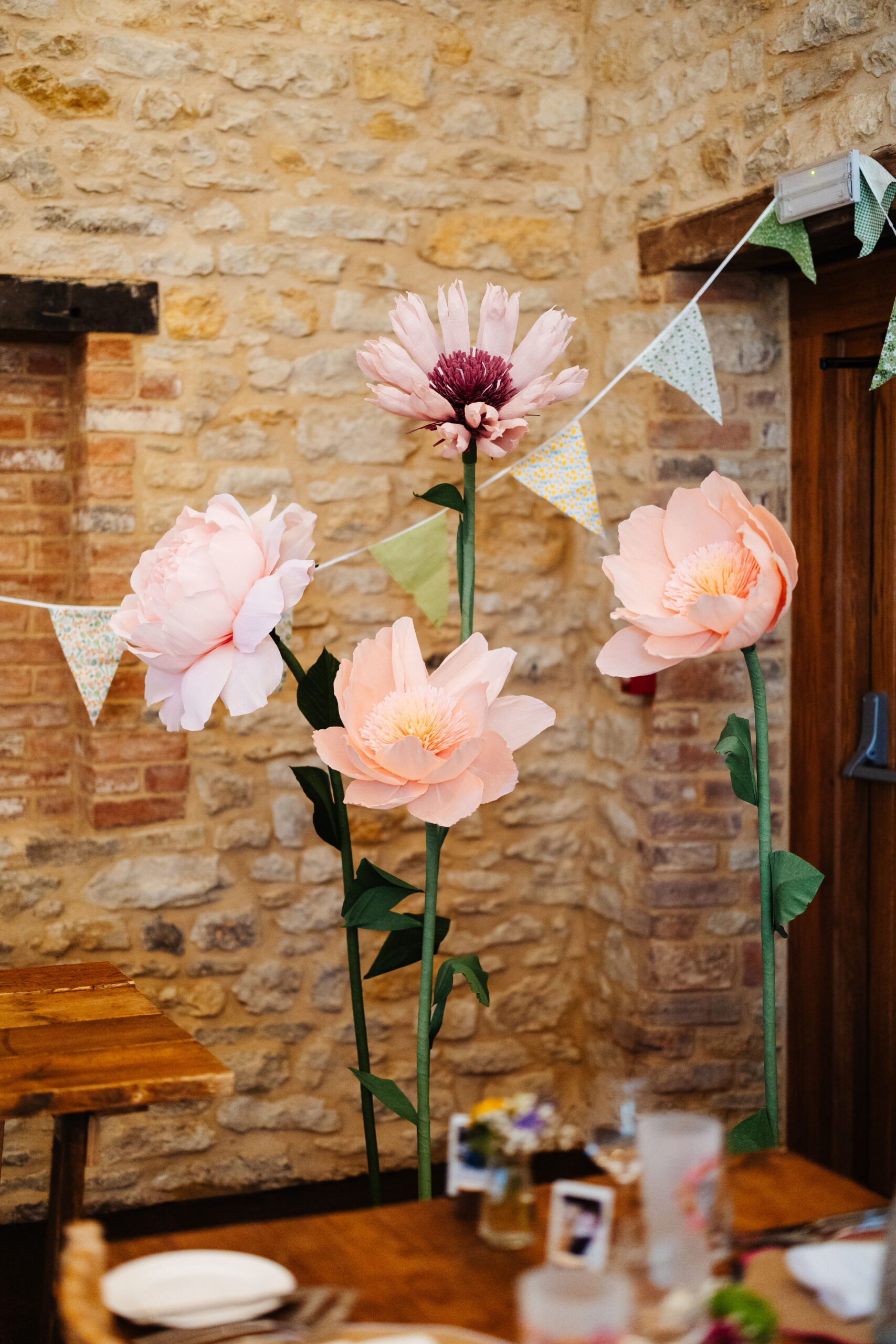 Four large paper, freestanding flowers. 