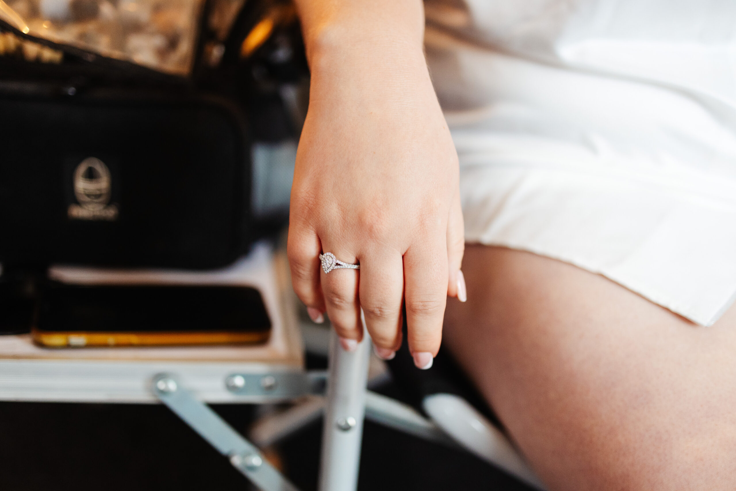 An image of the bride's hand, she has her engagement ring on and her nails are done in a french manicure style.