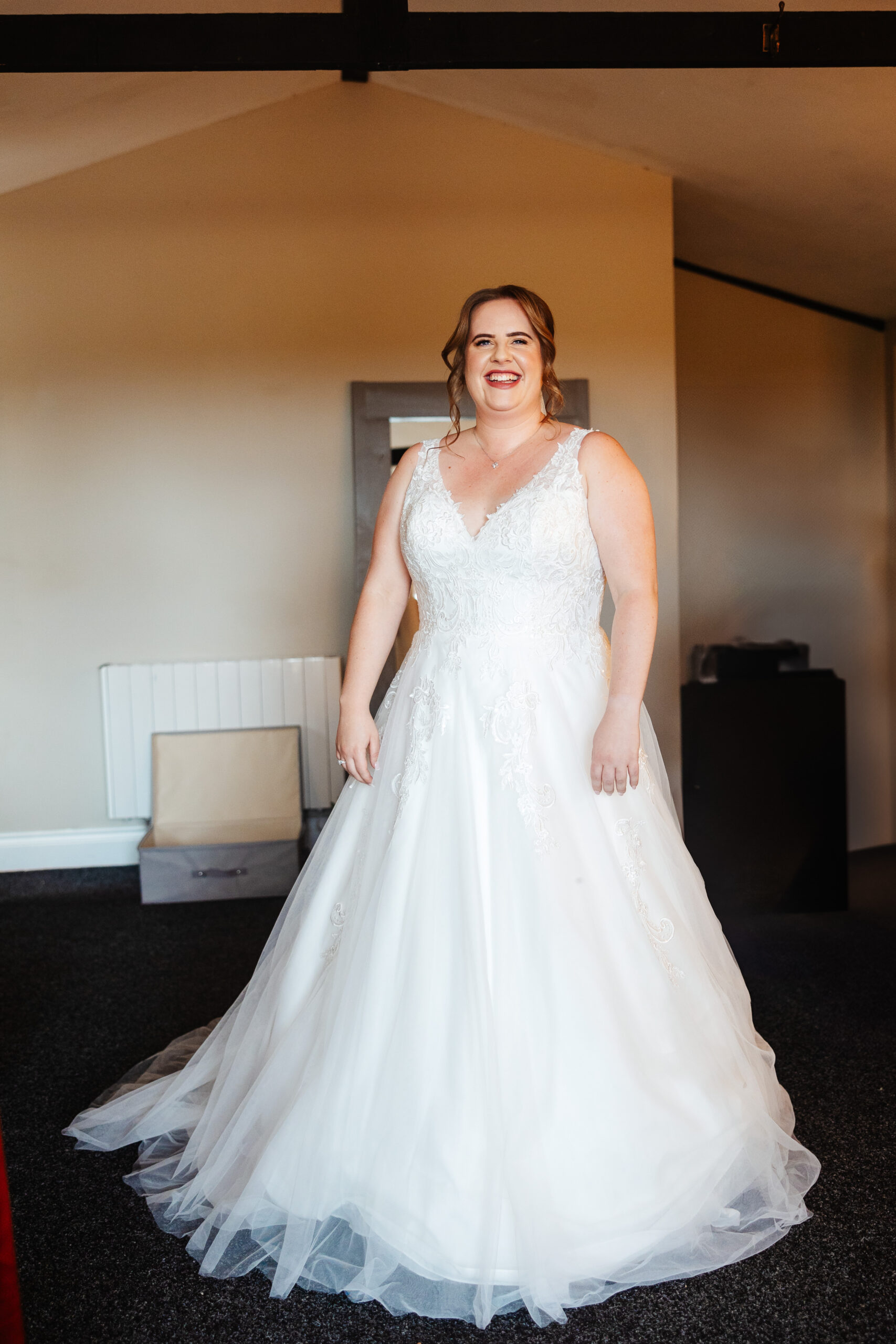 The bride in her wedding dress. She looks stunning and she is smiling at the camera.