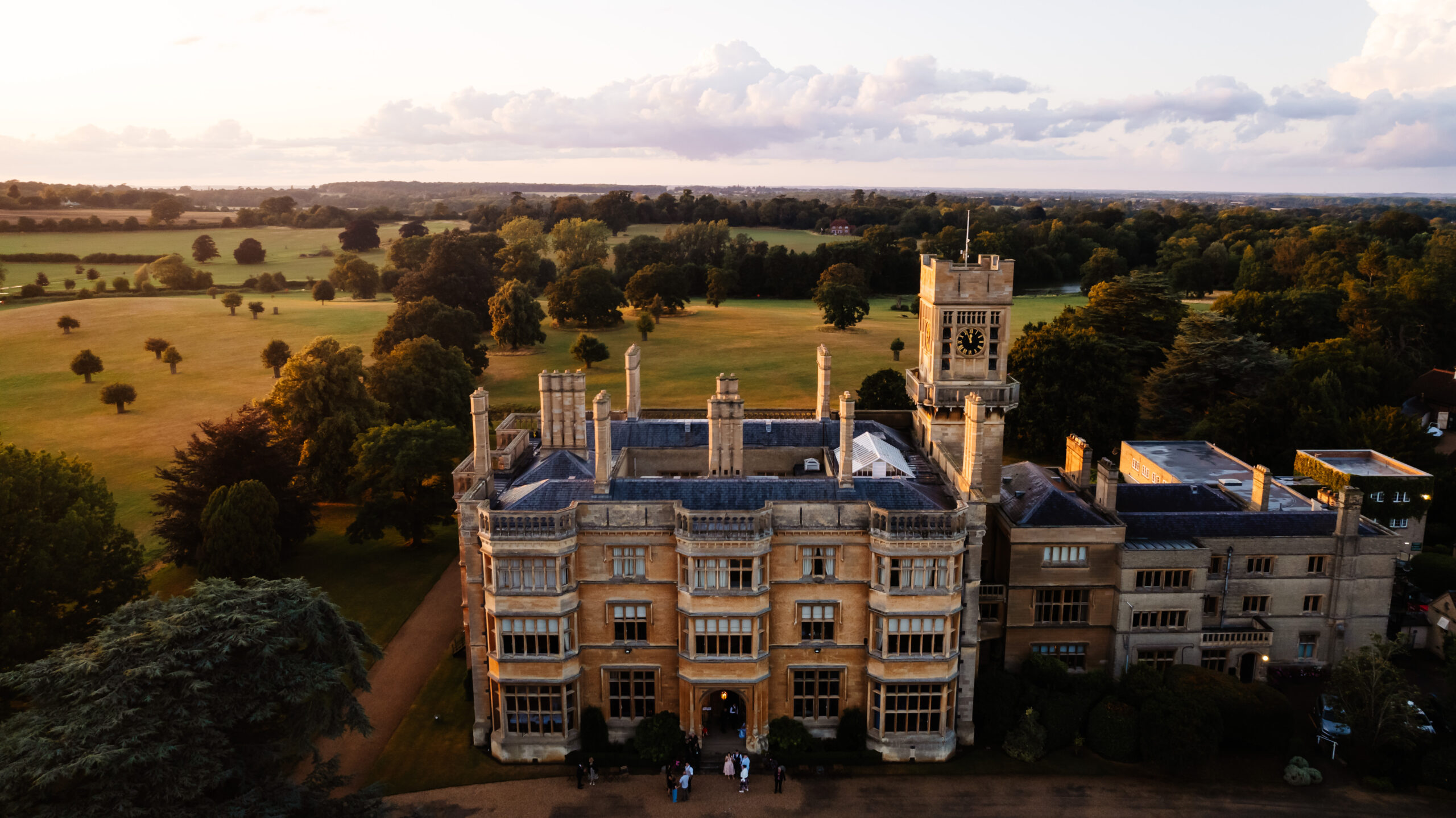 An aerial drone shot of Shuttleworth house. You can see guests in the entrance of the doorway to the venue and you can see the fields surrounding it too.