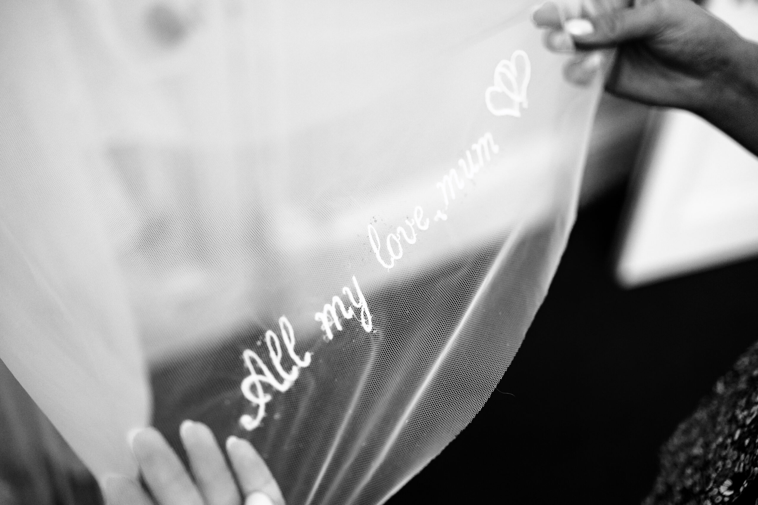 The bottom of a bride's veil. It is embroidered with All my love, Mum, on it.