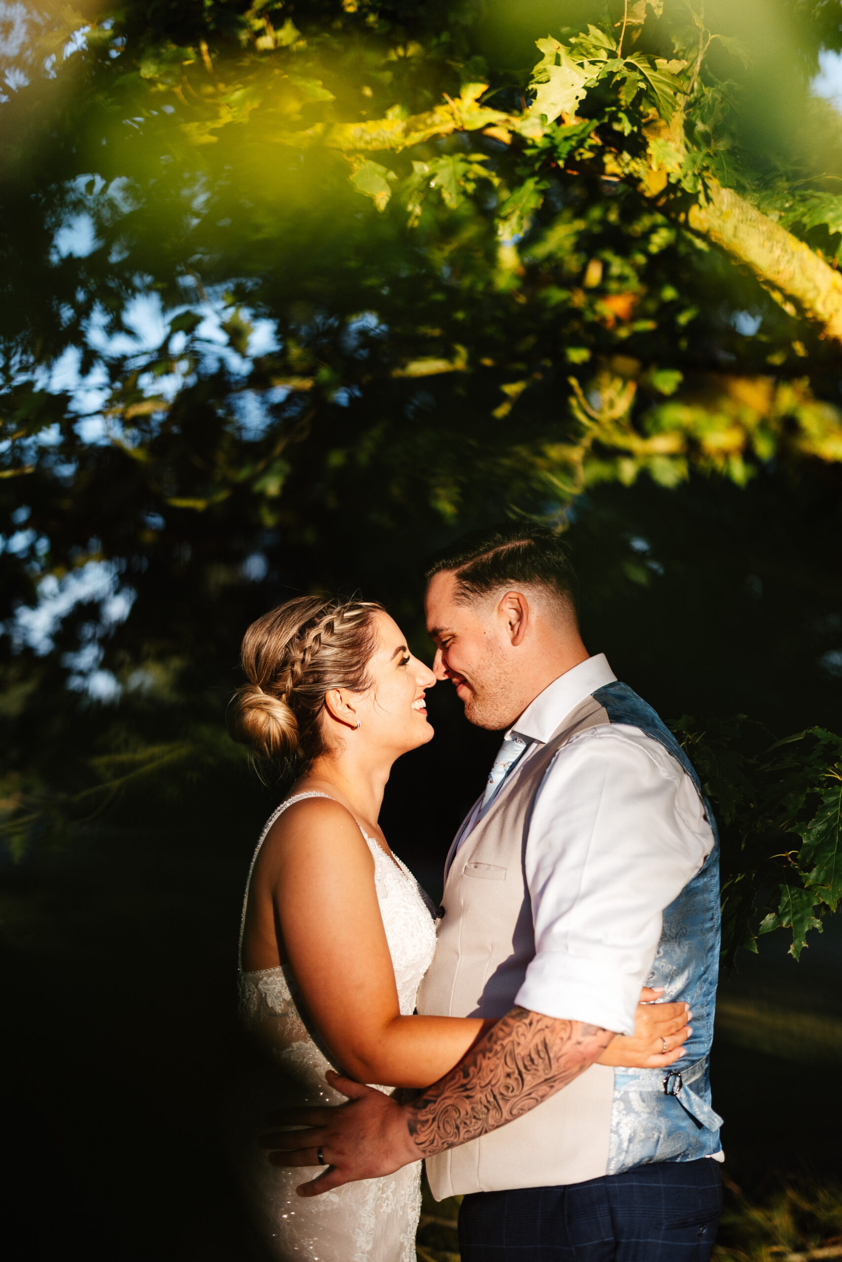 A photo of the bride and groom. They are embracing, looking at each other and smiling.