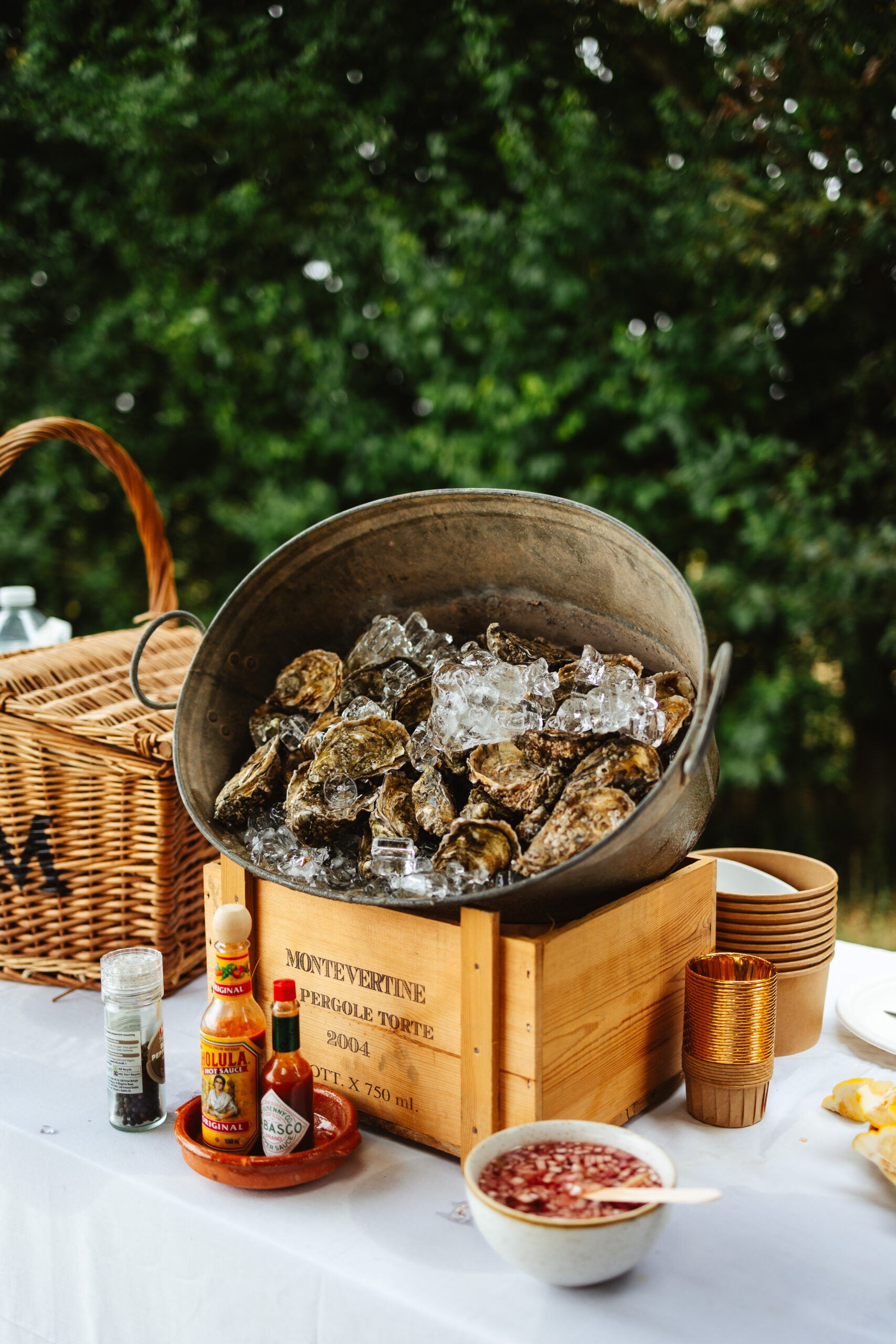 A metal bucket full of ice and oysters. These are for the guests to enjoy.