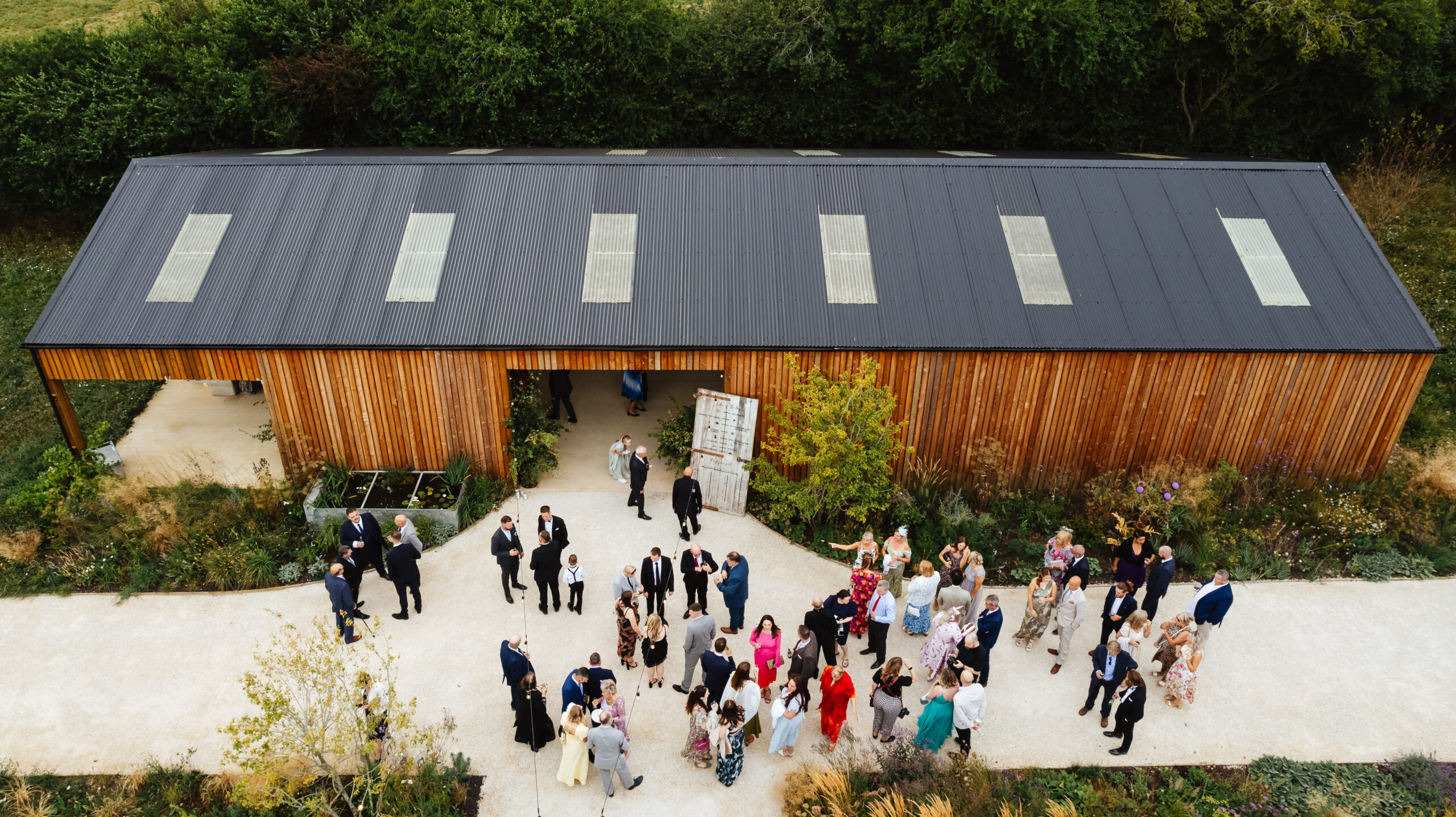 An aerial shot of the barn with guests congregating and enjoying themselves outside.