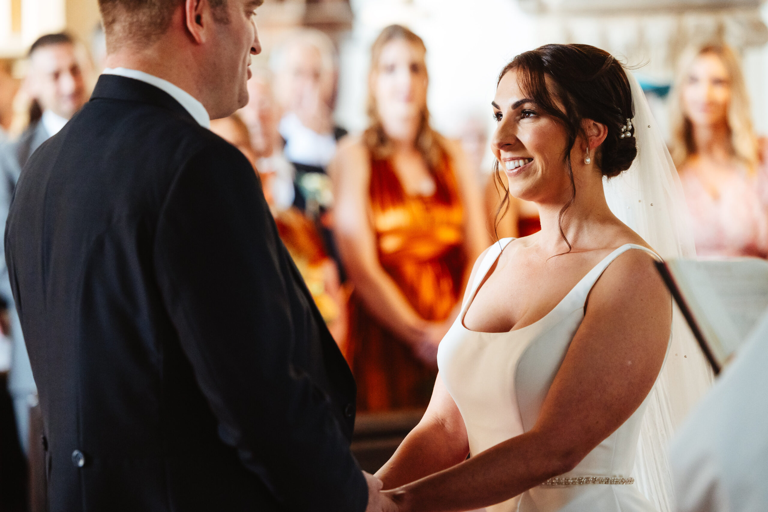 The bride and groom holding hands and looking at each other as they say their vows.