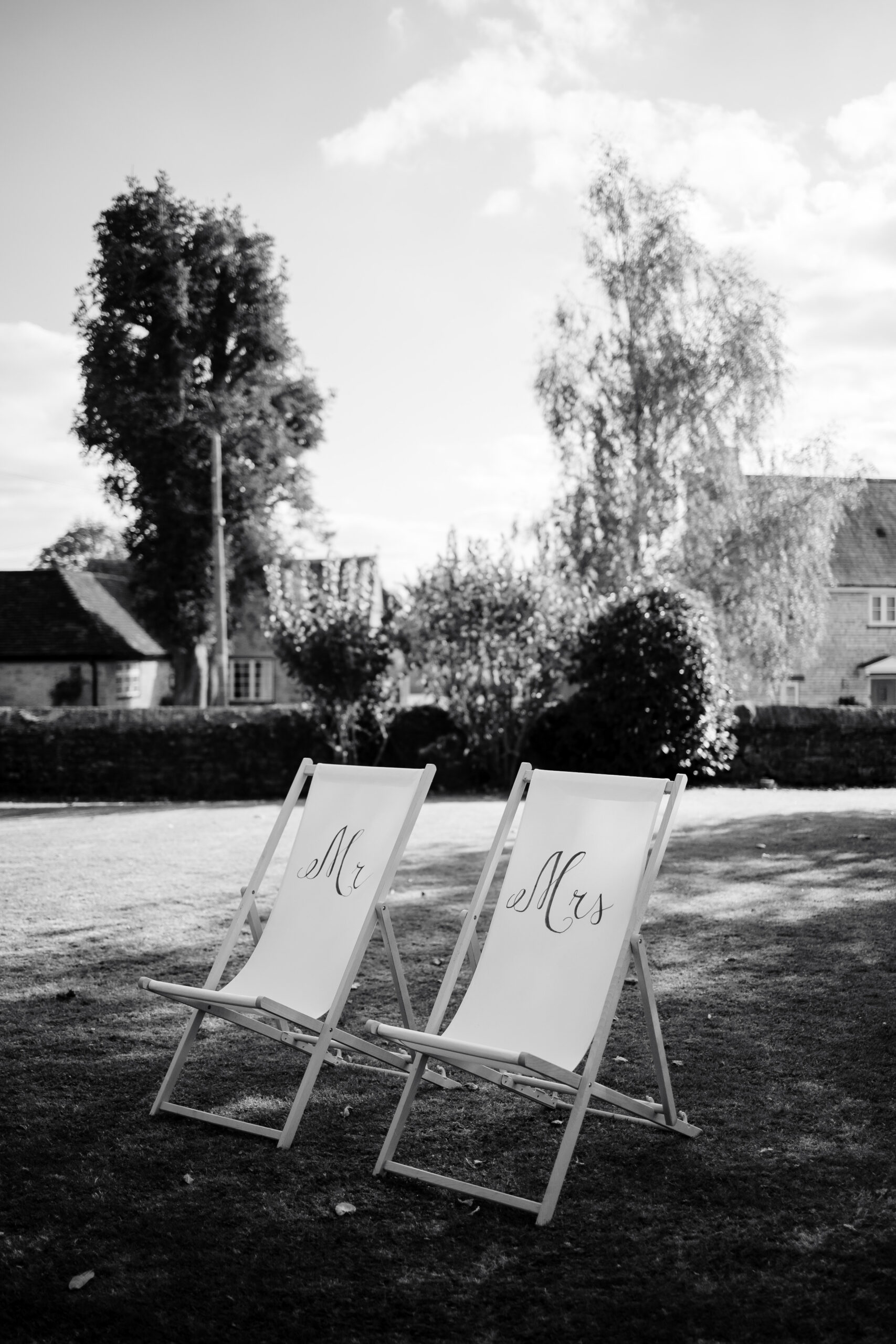 A black and white image of two deck chairs with Mr and Mrs written on them.