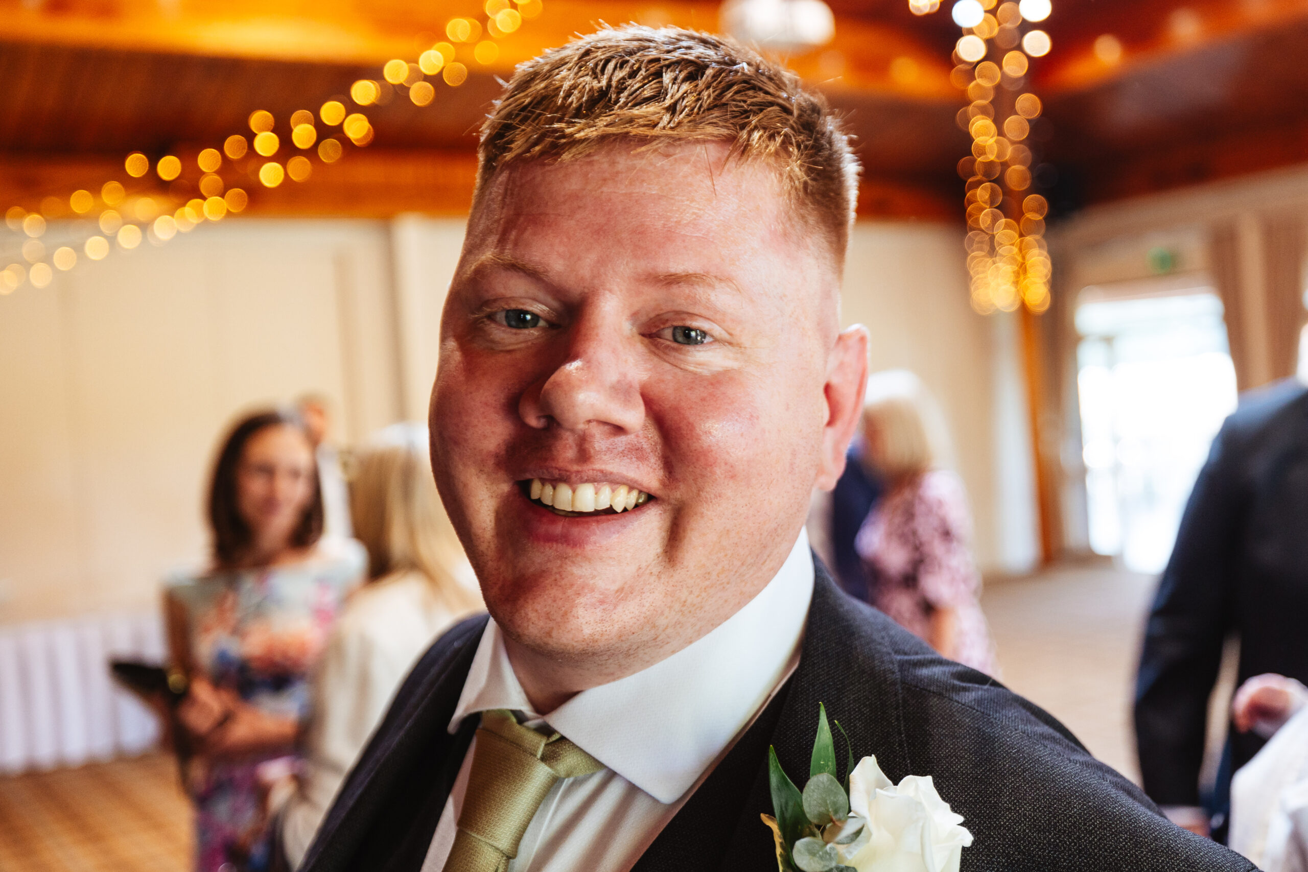 The groom looking at the camera and smiling. It is moments before he gets married.