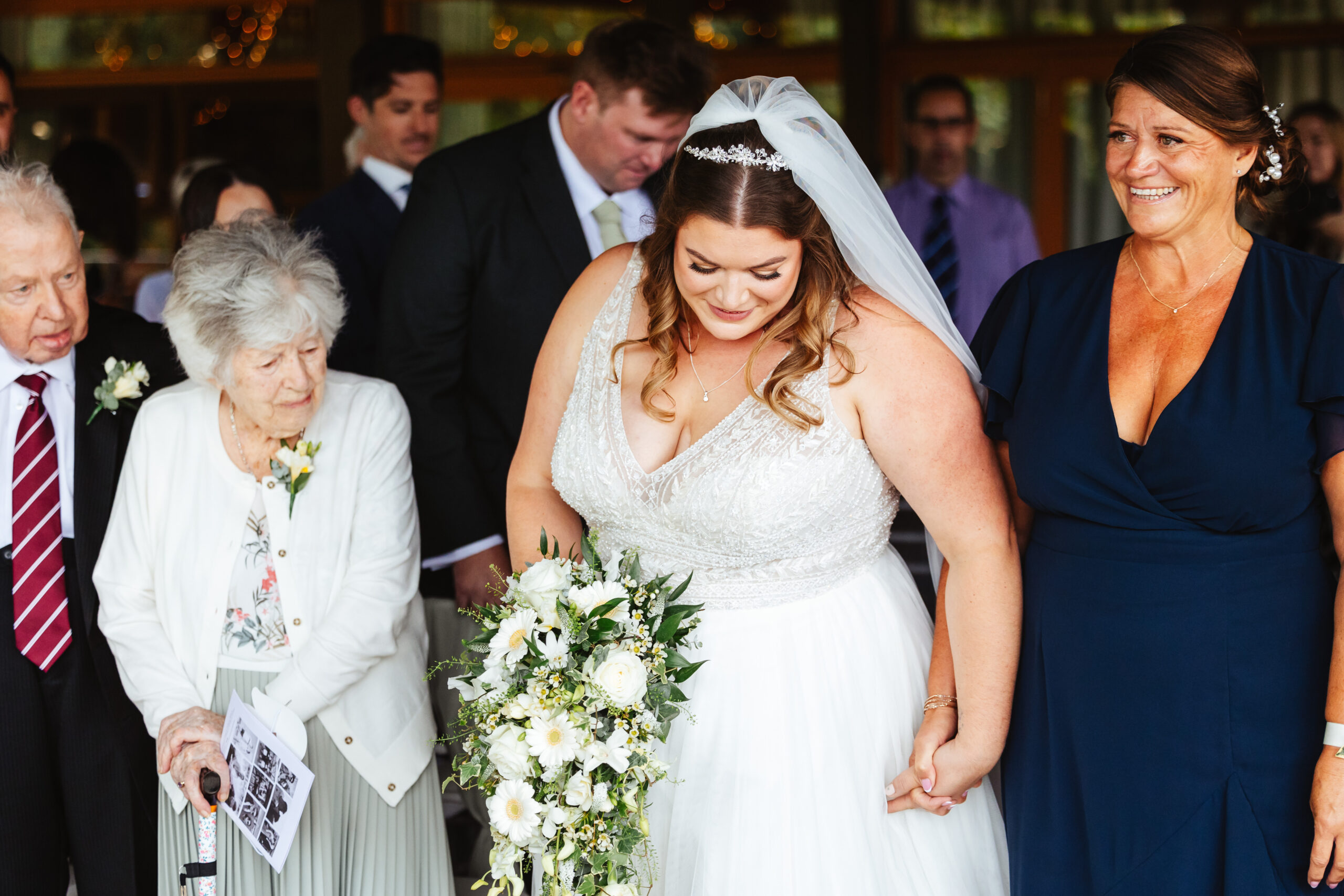 The bride walking in to her wedding. She is looking down, nervously but is smiling.